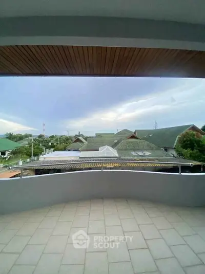 Spacious balcony with scenic view of suburban rooftops and lush greenery.