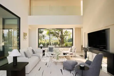 Luxurious modern living room with high ceilings and large windows offering stunning garden views.