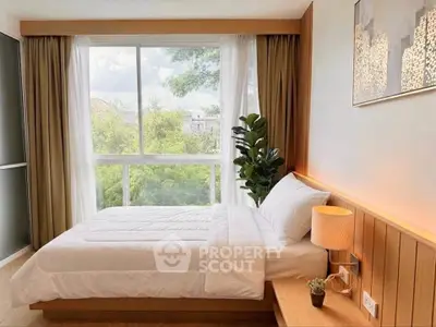 Bright and cozy bedroom with large window and modern decor