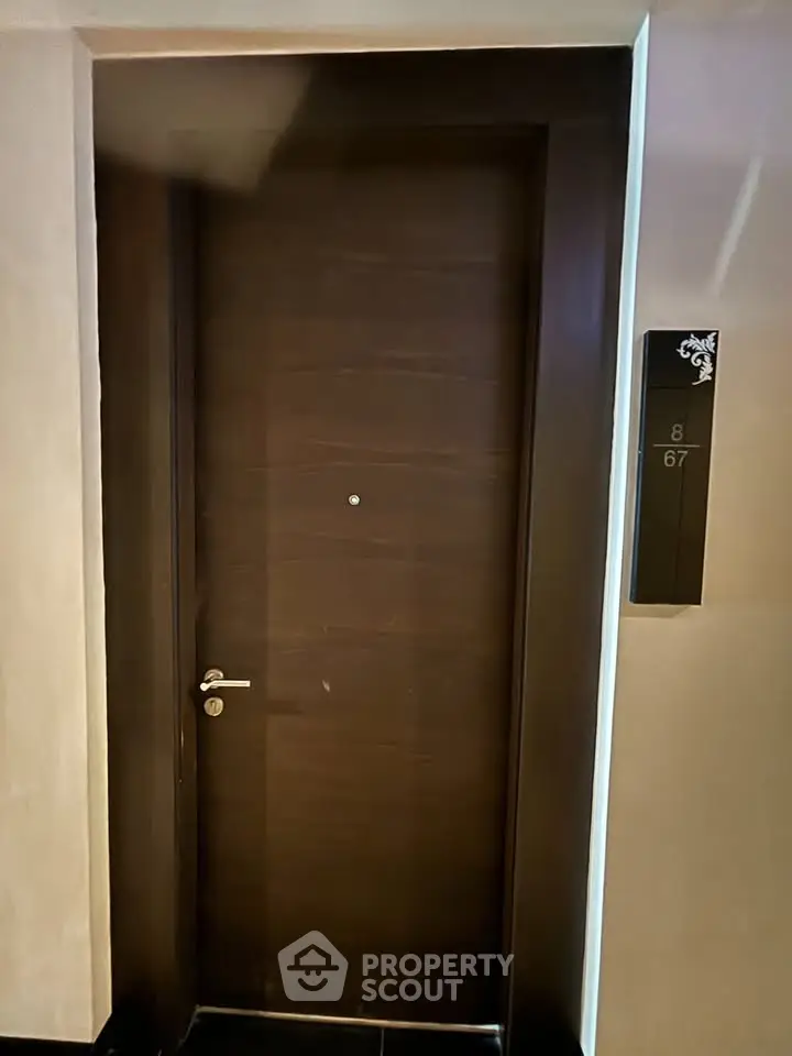 Elegant wooden apartment door with modern design and room number plaque.
