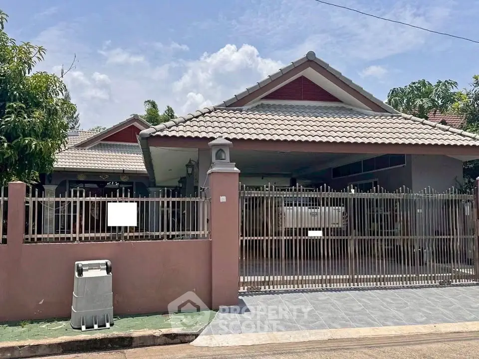 Charming suburban home with gated driveway and tiled roof, perfect for family living.