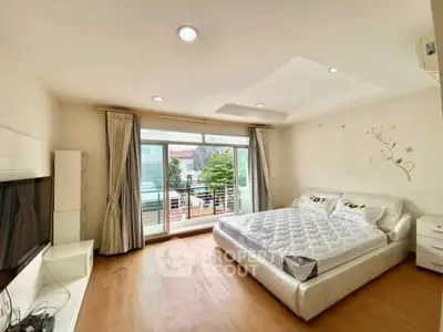 Spacious bedroom with large window and balcony access in modern apartment