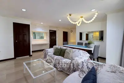 Spacious living room with elegant decor and modern lighting in a stylish apartment.