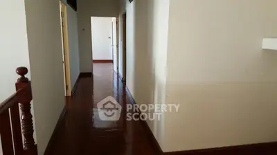 Spacious hallway with polished wooden floors and natural light