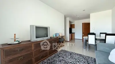 Spacious living room with vintage TV and elegant dining area in modern apartment.