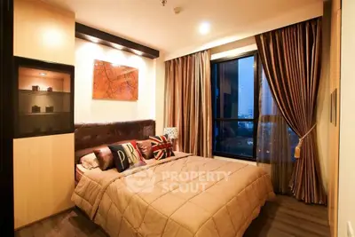 Cozy modern bedroom with stylish decor and large window view.