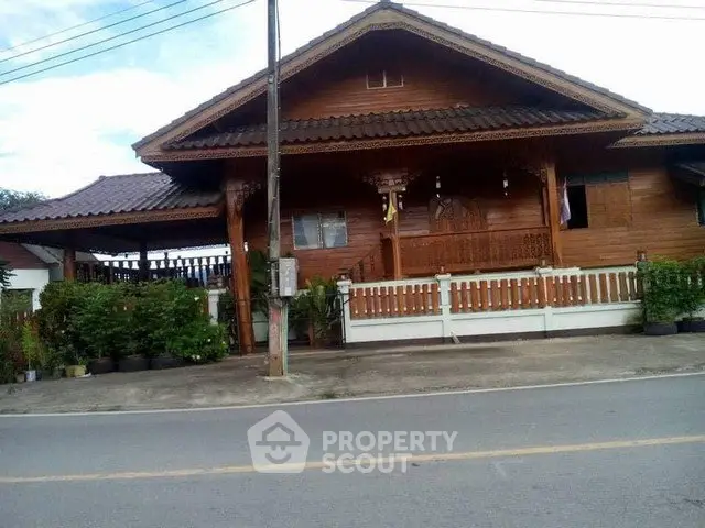 Charming traditional wooden house with lush greenery and inviting front porch.