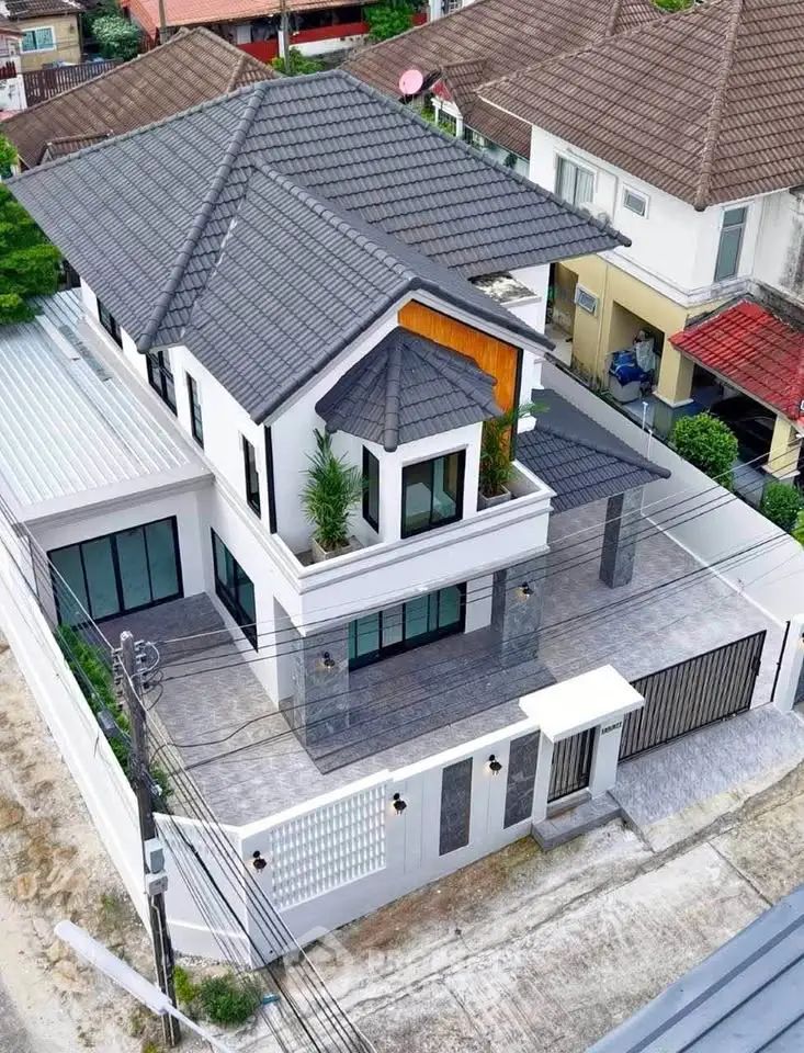 Stunning modern two-story house with sleek design and spacious outdoor area in a serene neighborhood.