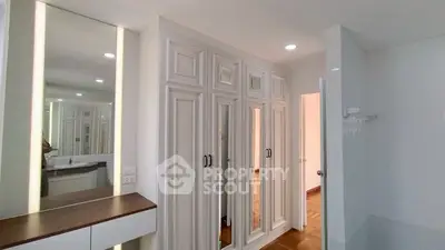 Spacious bedroom with elegant mirrored wardrobes and modern lighting