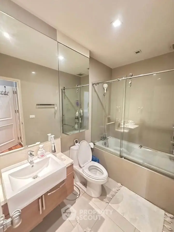 Modern bathroom with glass shower and sleek fixtures in a contemporary home.
