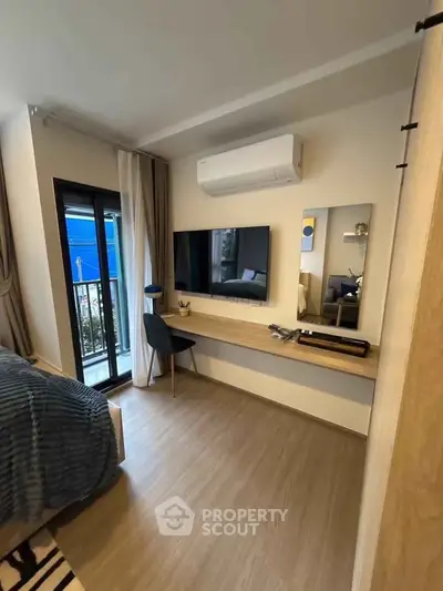 Modern bedroom with balcony access, featuring sleek design and air conditioning.