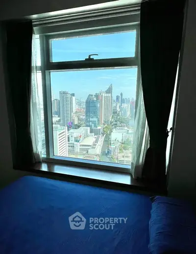 Stunning city view from a cozy bedroom window, perfect for urban living.