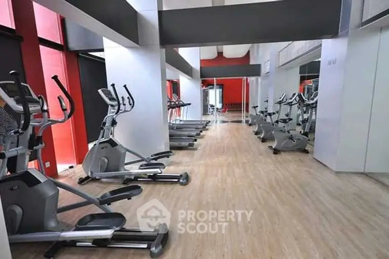 Modern gym with sleek exercise equipment and mirrored walls in a stylish residential building.