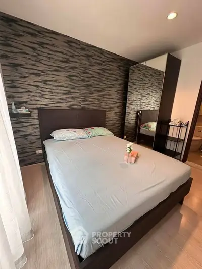 Modern bedroom with stylish accent wall and mirrored wardrobe