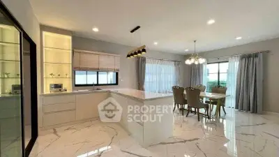 Luxurious open-layout kitchen and dining area with elegant marble flooring and modern lighting.