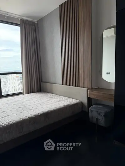 Modern bedroom with city view, featuring stylish wood paneling and sleek furniture.