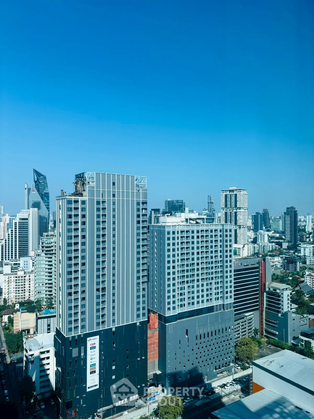 Stunning cityscape view showcasing modern high-rise buildings under a clear blue sky.