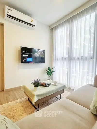 Modern living room with cozy sofa, wall-mounted TV, and large window with sheer curtains.