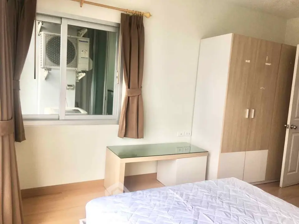 Bright bedroom with large window and modern furniture in a cozy apartment.