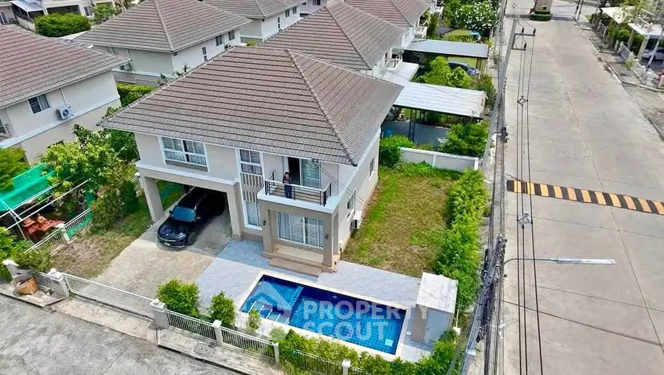 Stunning aerial view of a modern two-story house with private pool and lush garden in a serene neighborhood.