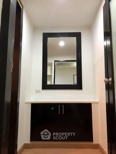 Modern bathroom with sleek black cabinetry and large mirror