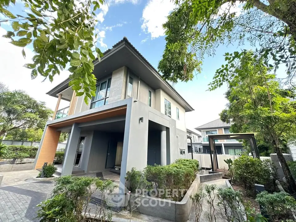 Modern two-story house with lush greenery and spacious driveway in a serene neighborhood.