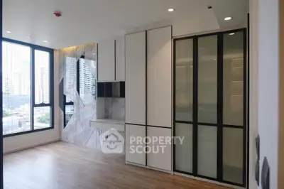 Modern minimalist living room with large windows and sleek built-in storage.