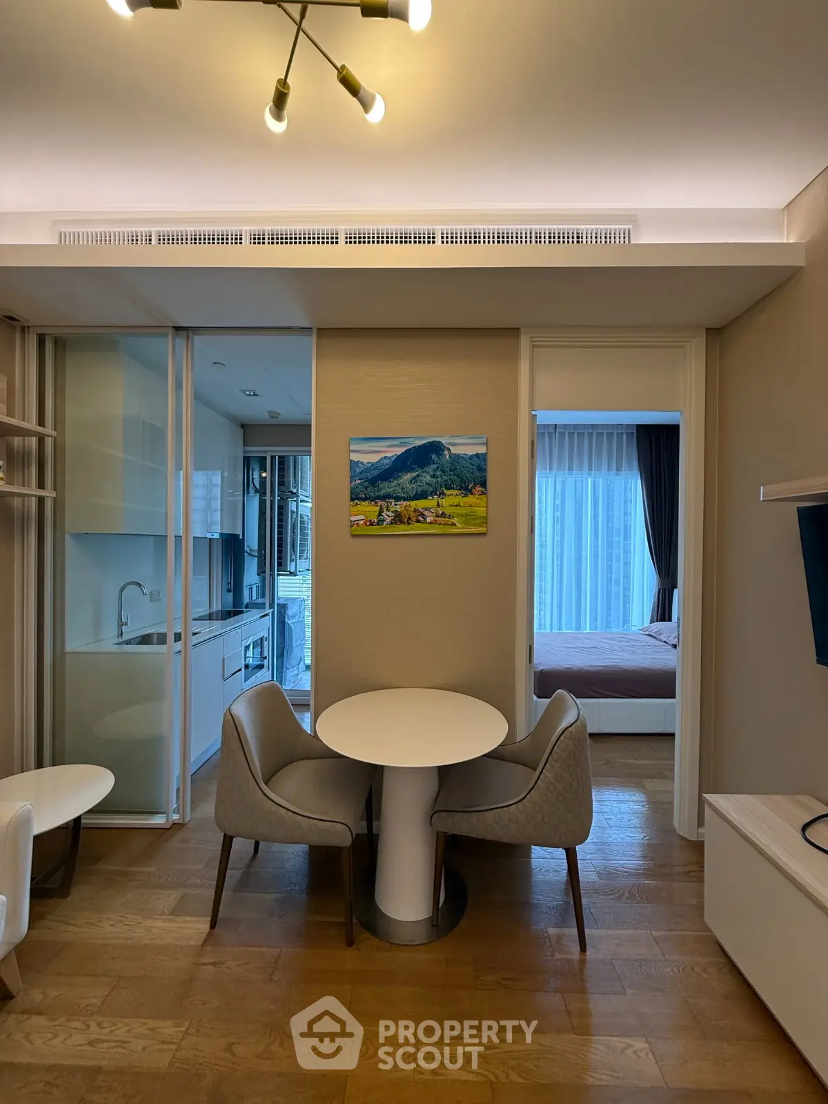 Modern apartment interior with open kitchen and cozy dining area, featuring elegant decor and natural light.