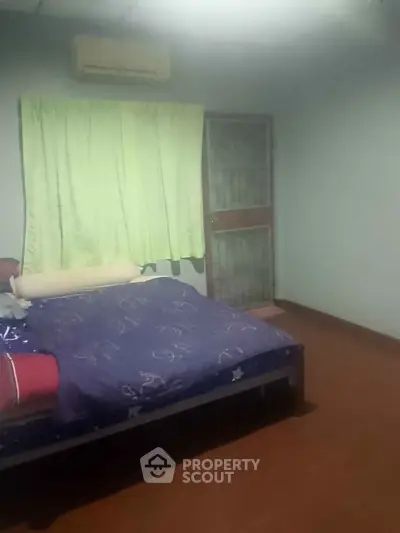 Cozy bedroom with air conditioning and simple decor, featuring a comfortable bed and natural light.