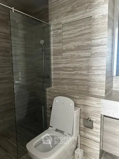 Modern bathroom with sleek design featuring glass shower and elegant tiling.