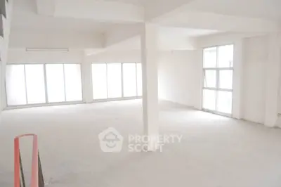 Spacious and well-lit commercial space with large windows and high ceilings, perfect for a bespoke office or retail showroom.
