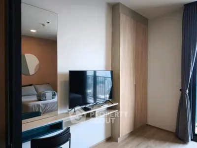 Modern bedroom with TV, wardrobe, and balcony view