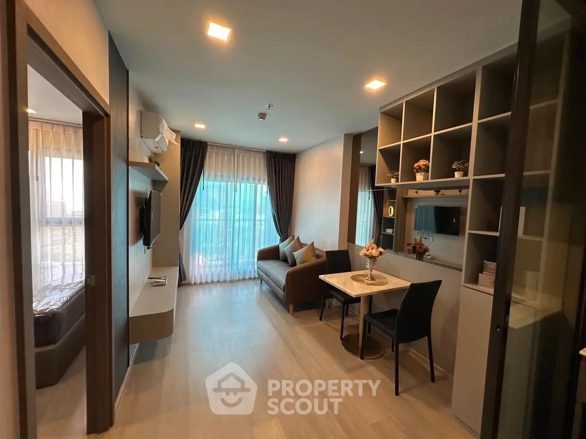 Modern living room with cozy dining area and stylish shelving in a well-lit apartment.