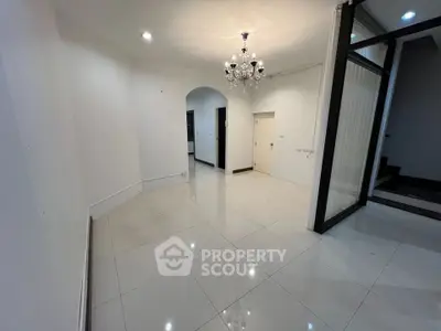 Spacious modern living room with elegant chandelier and glossy tile flooring