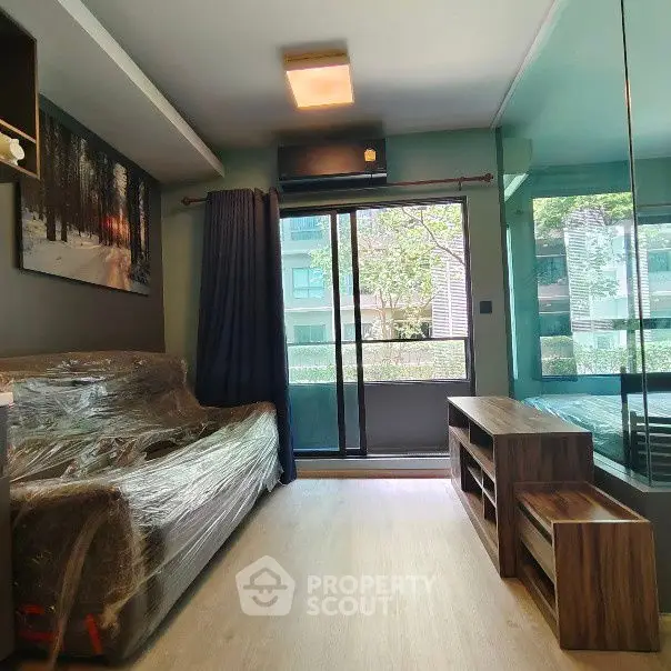 Modern living room with large window and stylish furniture in urban apartment.