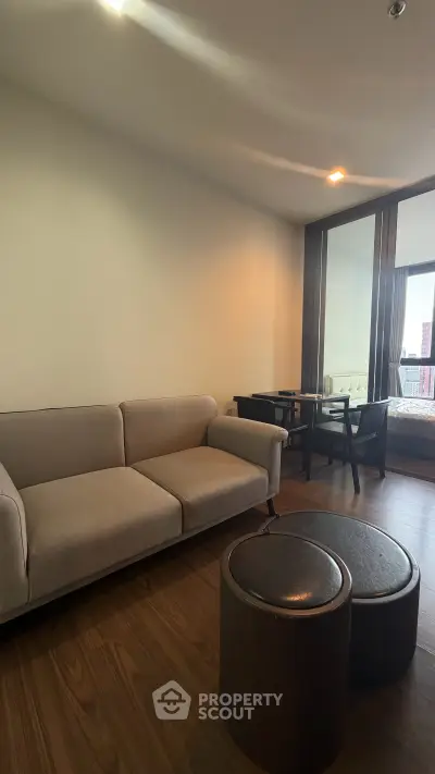 Modern living room with cozy sofa and stylish dining area in open layout apartment.