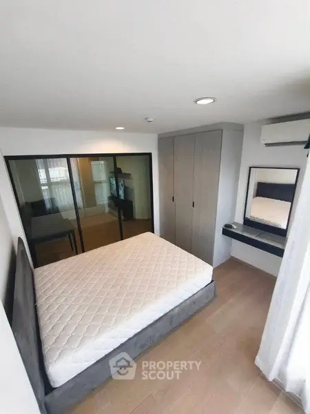 Modern bedroom with sleek design, featuring a comfortable bed, built-in wardrobe, and stylish vanity area.