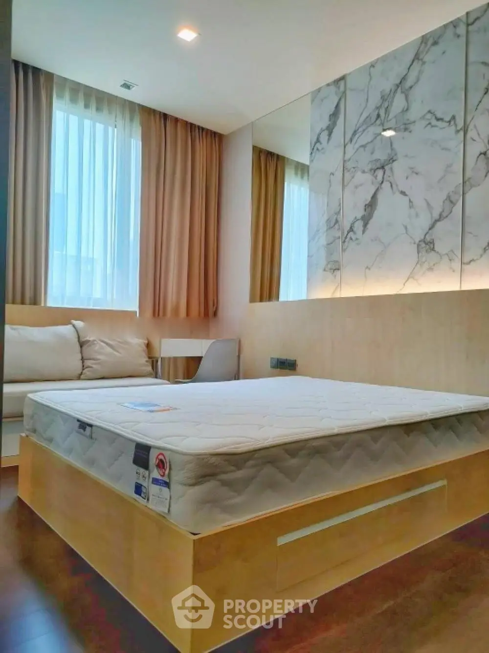 Modern bedroom with stylish decor and natural light, featuring a comfortable bed and elegant furnishings.