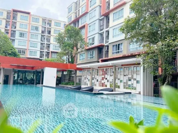 Modern apartment complex with a stunning outdoor pool and lush greenery.