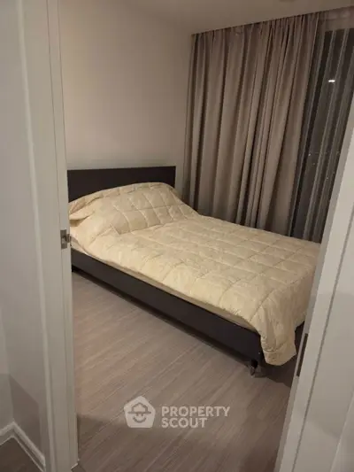 Cozy bedroom with modern decor and elegant curtains, perfect for relaxation and comfort.