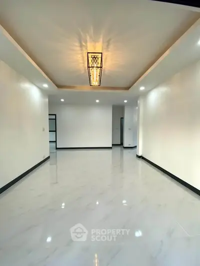 Spacious modern living room with elegant lighting and glossy tiled flooring.