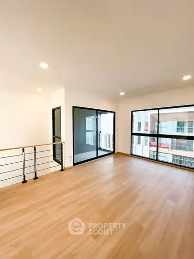 Spacious modern living room with large windows and wooden flooring