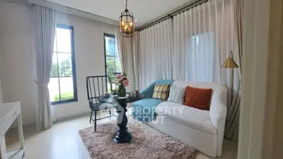 Charming living room with cozy sofa, elegant lighting, and large windows.