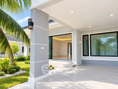 Modern luxury home exterior with spacious patio and lush garden view.