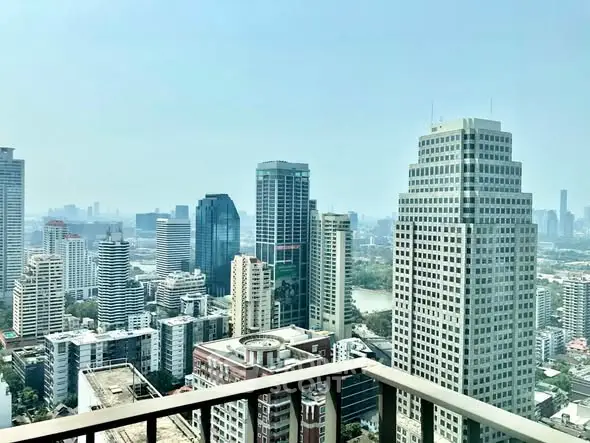 Stunning cityscape view from high-rise balcony in urban setting, showcasing modern architecture.