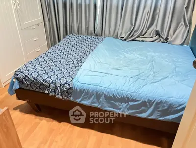 Cozy bedroom with wooden flooring and stylish blue bedding