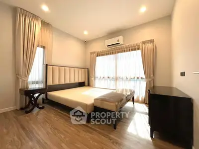 Spacious bedroom with elegant furnishings and natural light