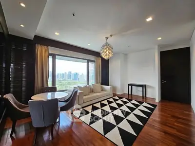 Luxurious living room with city view, elegant chandelier, and modern decor.