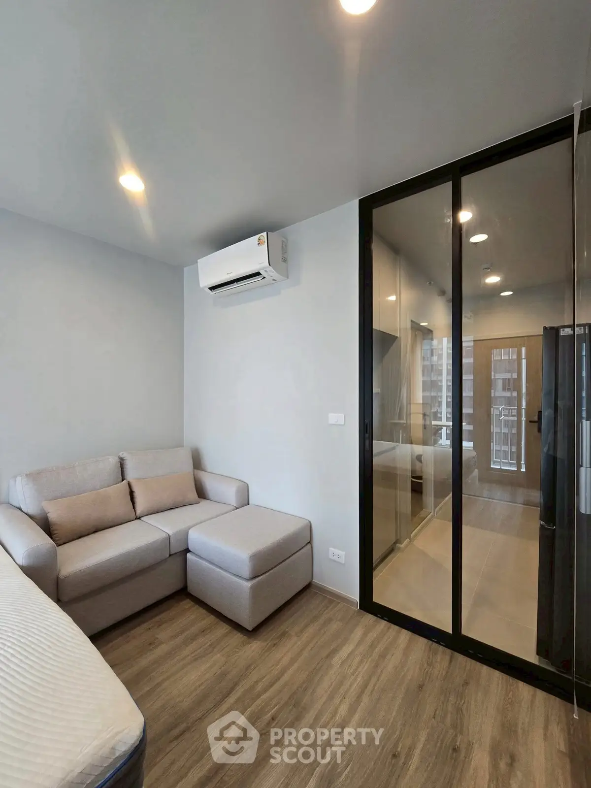 Modern living room with glass partition and cozy sofa in stylish apartment.