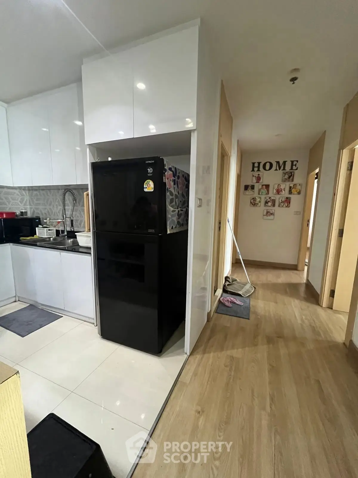 Modern kitchen with sleek black fridge and stylish decor in a cozy apartment.